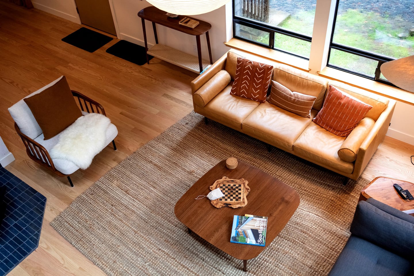 Sea Ranch living room with leather sofa and large windows overlooking the grounds